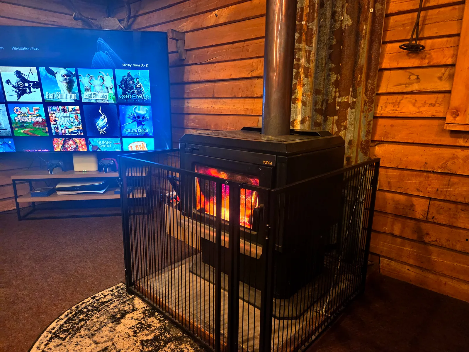 The Southland-made Yunca woodburner in the common room, beside the 85-inch TV showing the PS5 game library