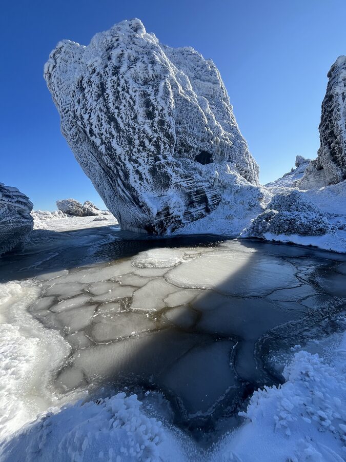 A rime-ice-caked tor over a frozen, cracked tarn