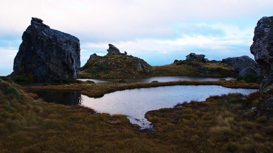 Granite tors reflected in a tarn at dusk