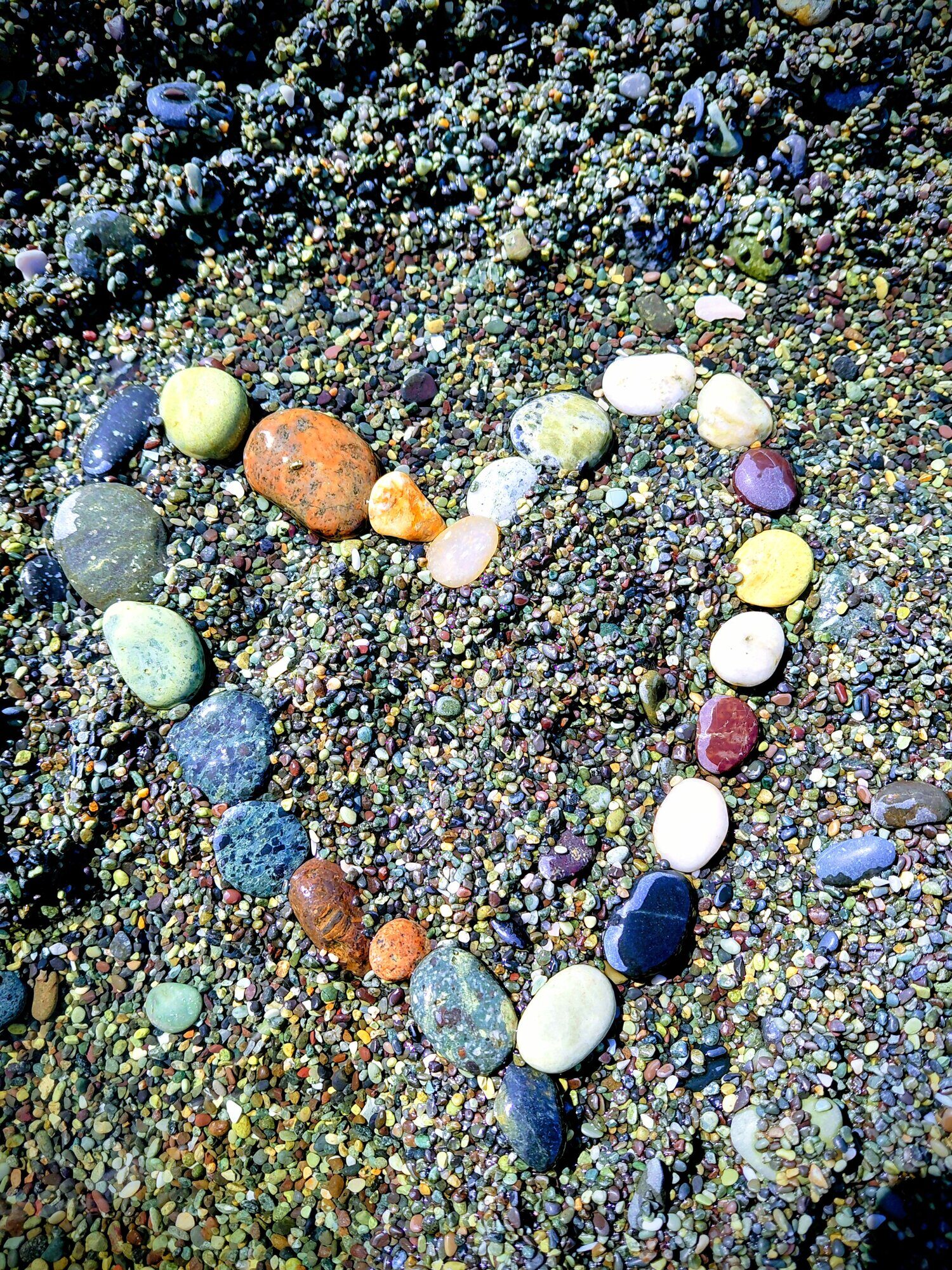 Heart-shaped arrangement of gemstone beach pebbles