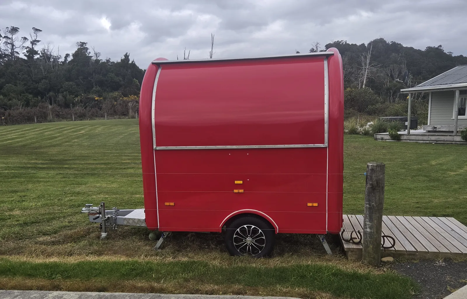 The Rarakau Kai food cart, a red trailer on the lawn beside the car park