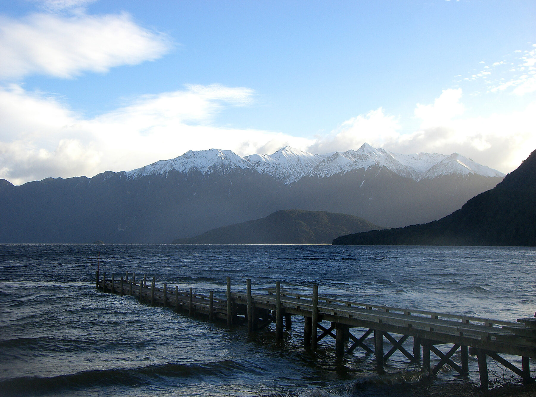 The pier at Lake Hauroko, with snow-capped Fiordland mountains behind